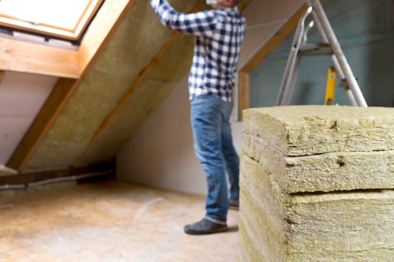 A man installing roof insulation layer.