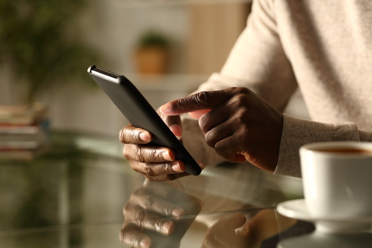Man's hands checking smart phone at night.