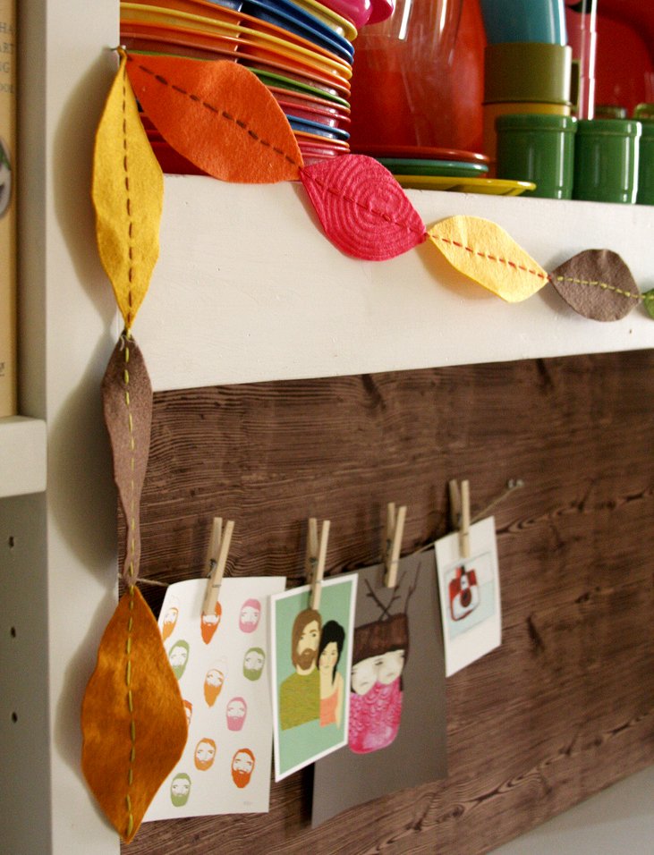 Handmade felt leaf garland in fall colors decorates a fireplace mantle.