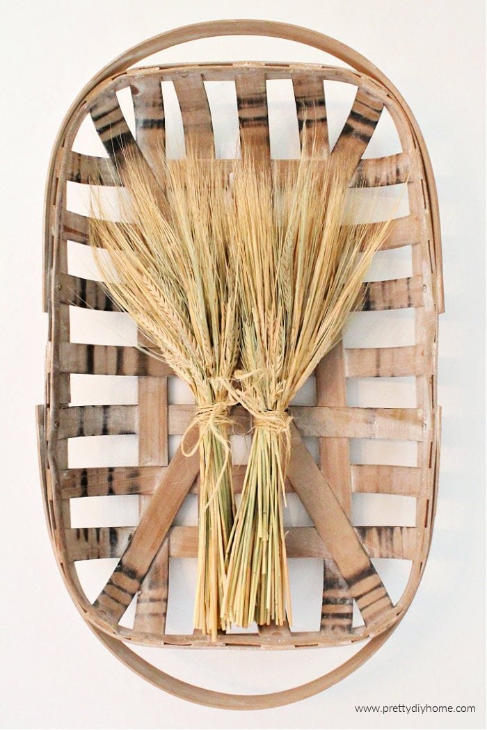 Overhead view of dried wheat stalks in a flat basket.