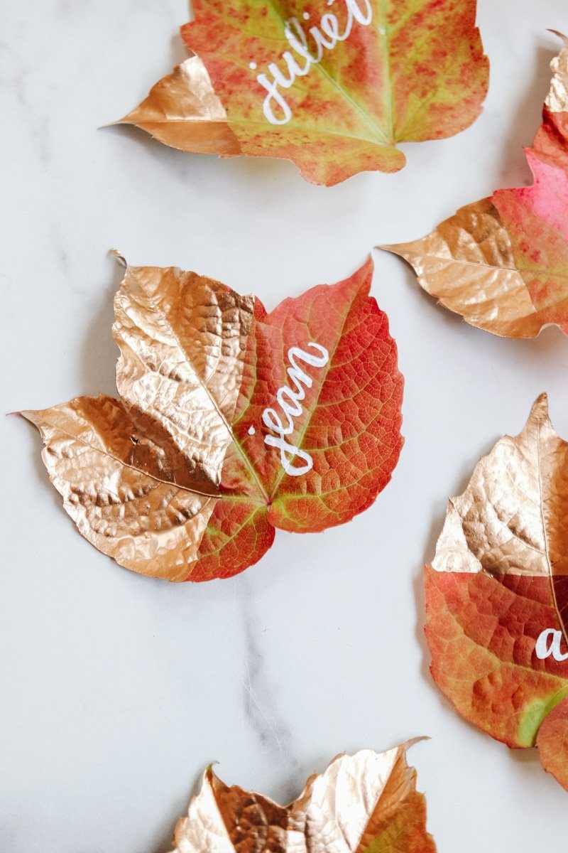 Fall leaves dipped in gold paint and personalized to be used as placecards.