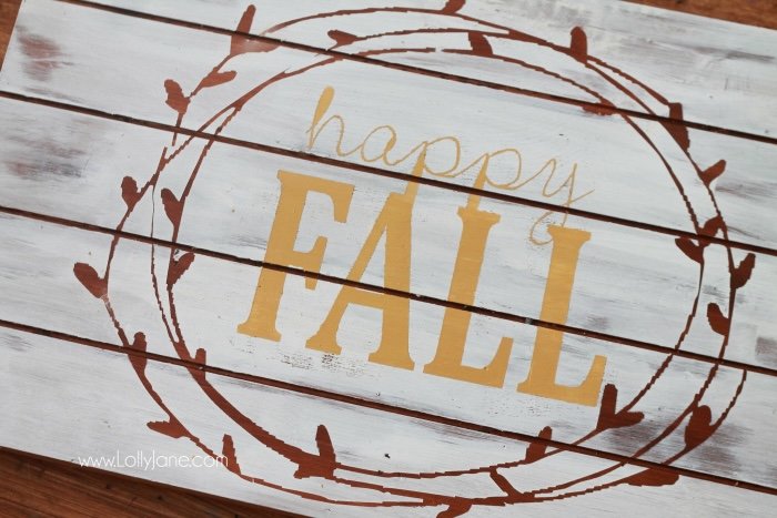 A "Happy Fall" sign made of a wood pallet painted white with fall motifs.