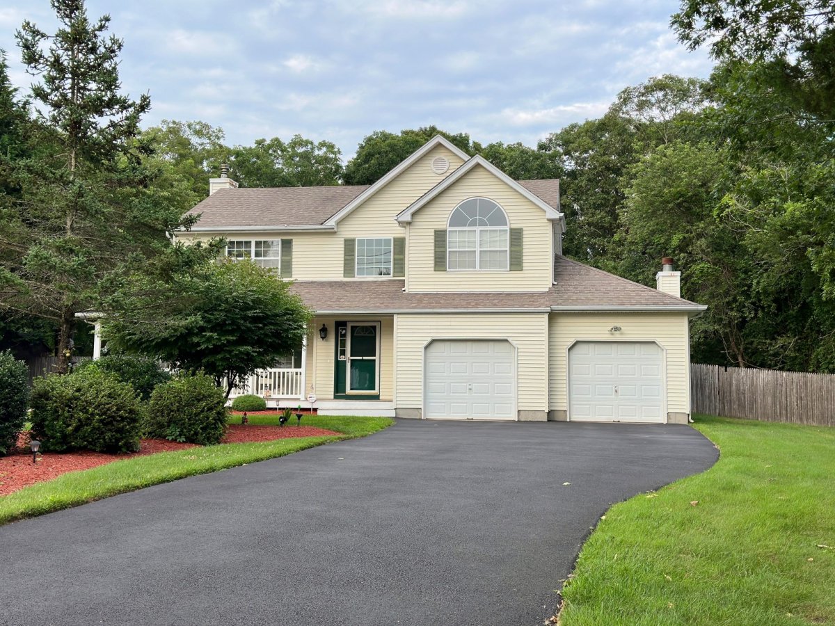 Large, contemporary house with attached, two-car garage and asphalt driveway.