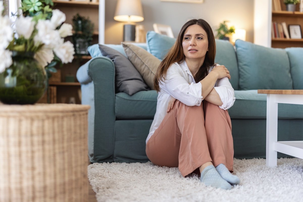 Thinking, sad and woman in home on the floor.