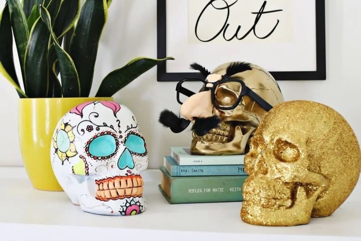Three decorated skulls on the shelf.