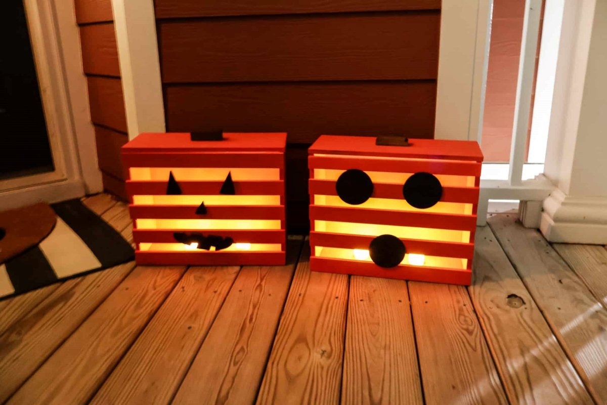 Two DIY boxes that are decorated as glowing Halloween pumpkins.