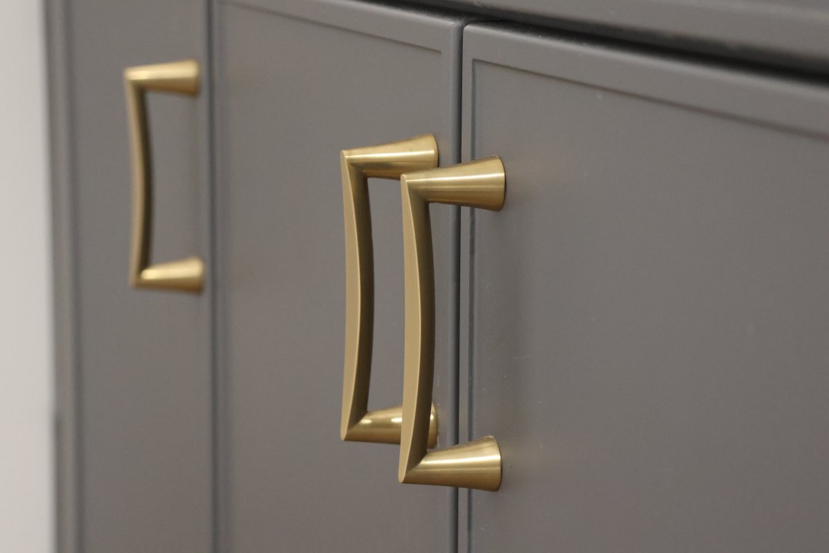 Gold cabinet pulls on putty-colored cabinets.