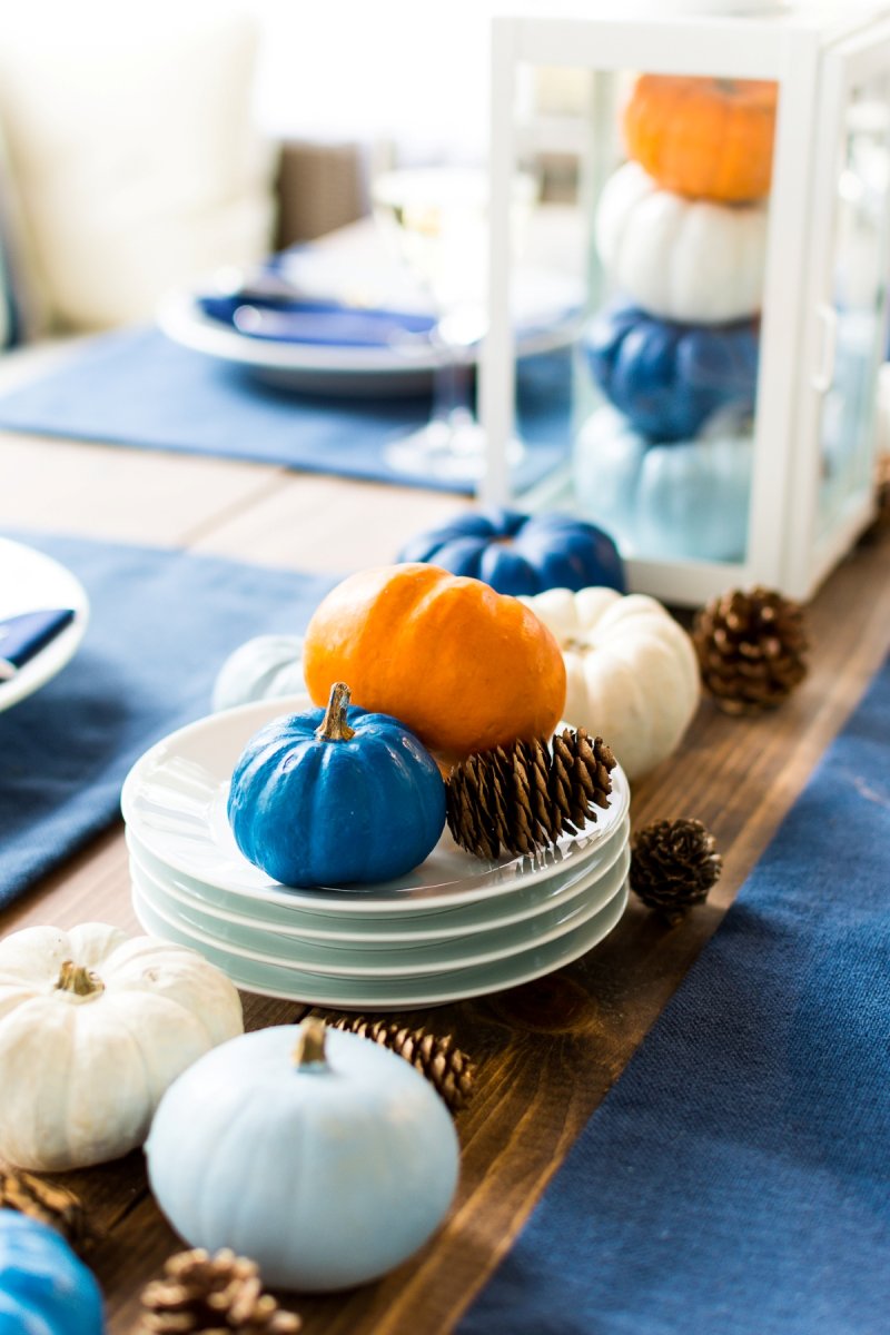 Small painted pumpkins used to decorate a festive Thanksgiving table setting.