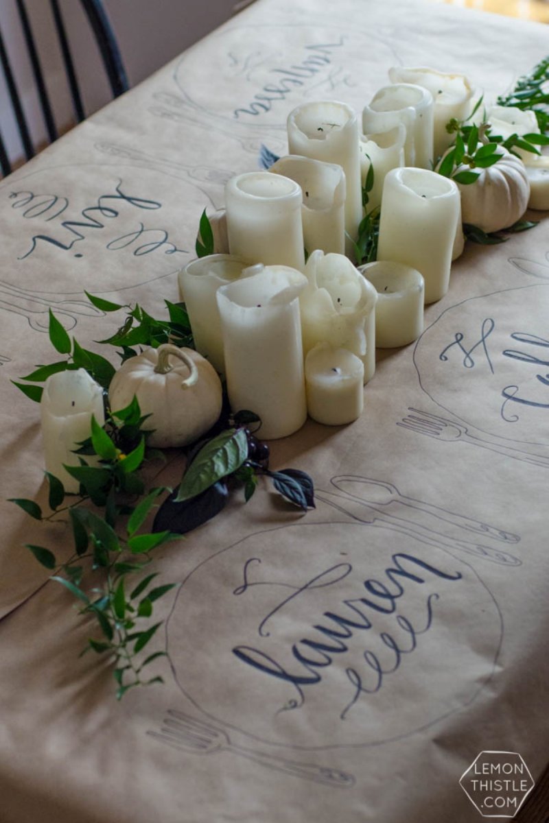 An arrangement of white pillar candles of varying heights on the dinner table.