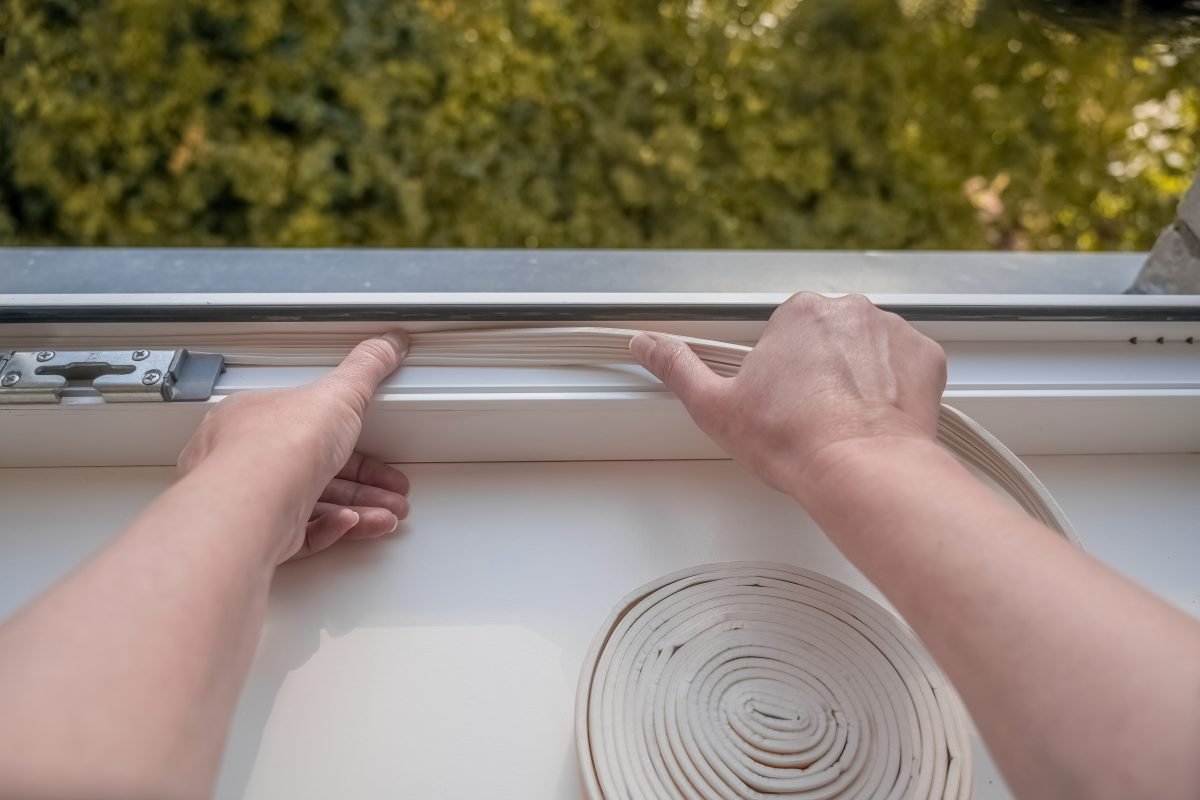 Closeup of hands adding sealing on a window
