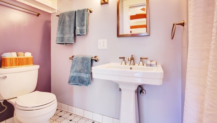Lavender walls in a bathroom with white appliances.