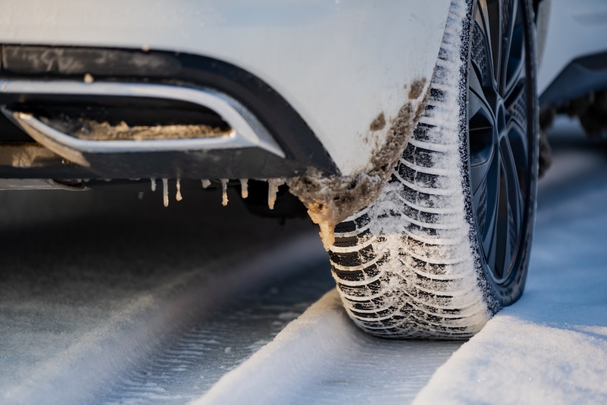 An SUV driving on snow tires in the wintertime.