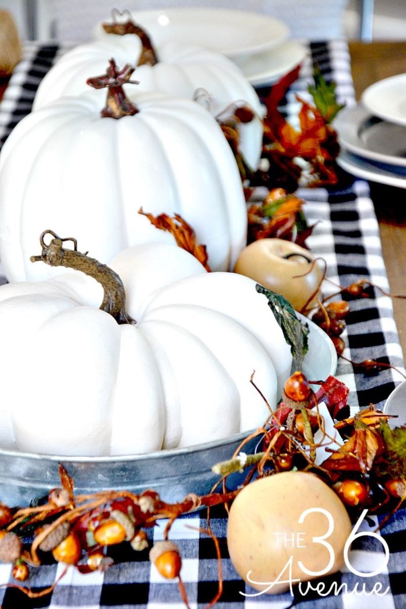 A grouping of faux white pumpkins and other fall elements to decorate a Thanksgiving Day table.